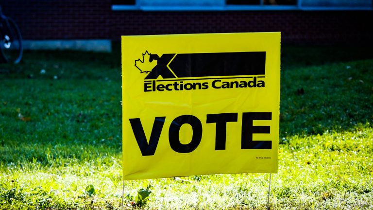 Fanion d’Élections Canada avec l’inscription « VOTE » à l’extérieur d’un lieu de vote.