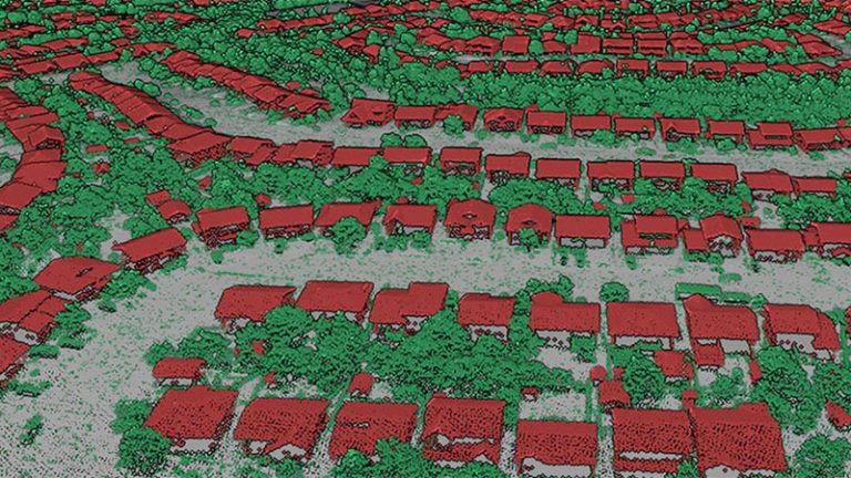 Une vue 3D des nuages de points lidar du dessus d'un quartier de maisons et d'arbres. Les points correspondant aux bâtiments, aux arbres et au sol ont été colorés en rouge, vert et gris, respectivement.